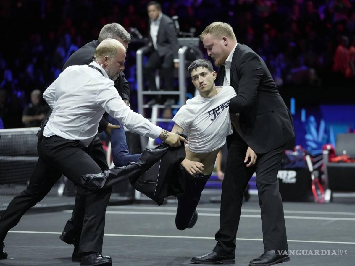 $!La seguridad se lleva a un hombre después de que se prendiera fuego en su brazo durante una protesta en el O2 de Londres.