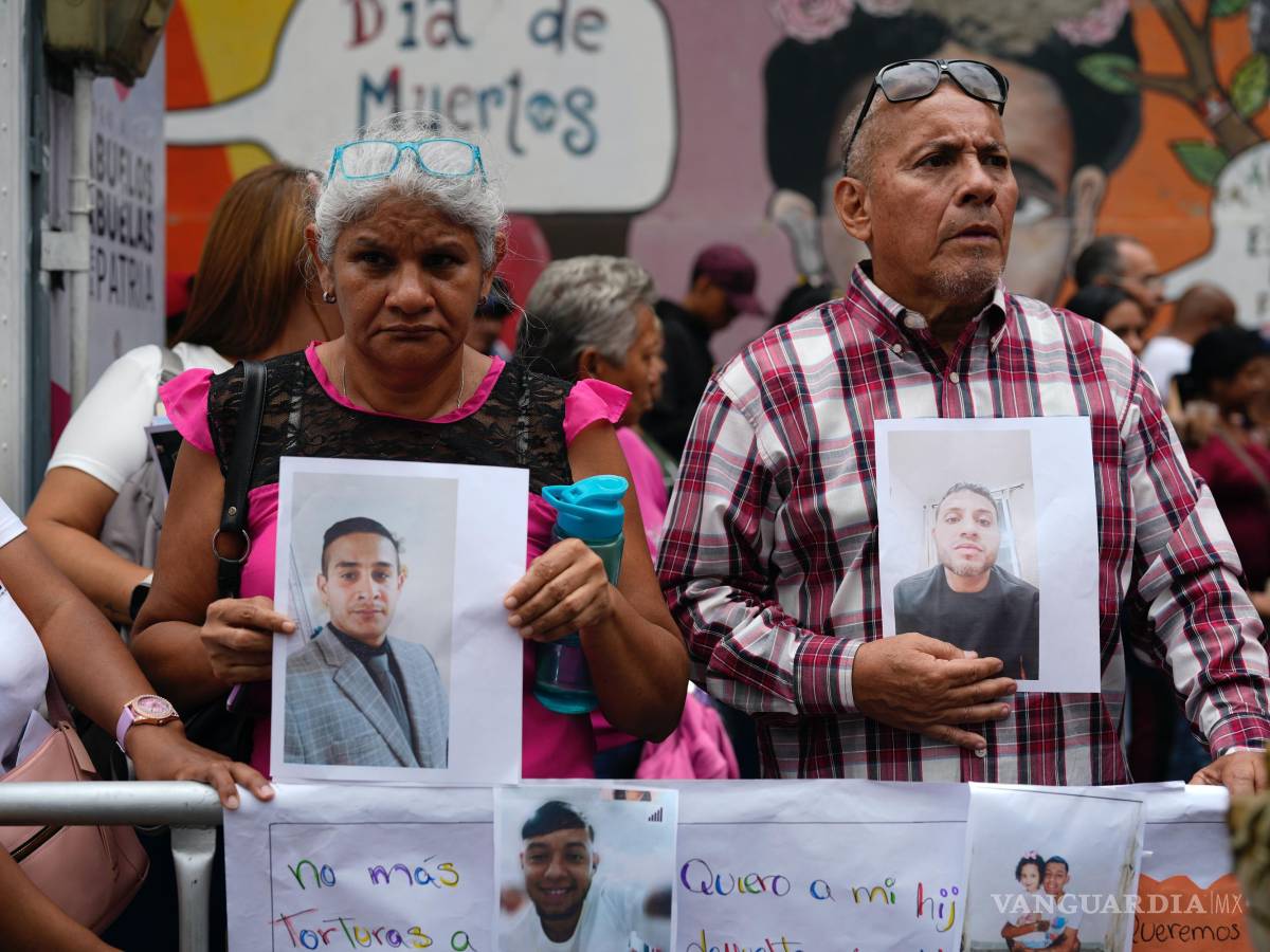 $!Personas con fotografías de parientes migrantes, de los que dicen fueron detenidos en EU y aguardan a ser deportados, protestan en Caracas.