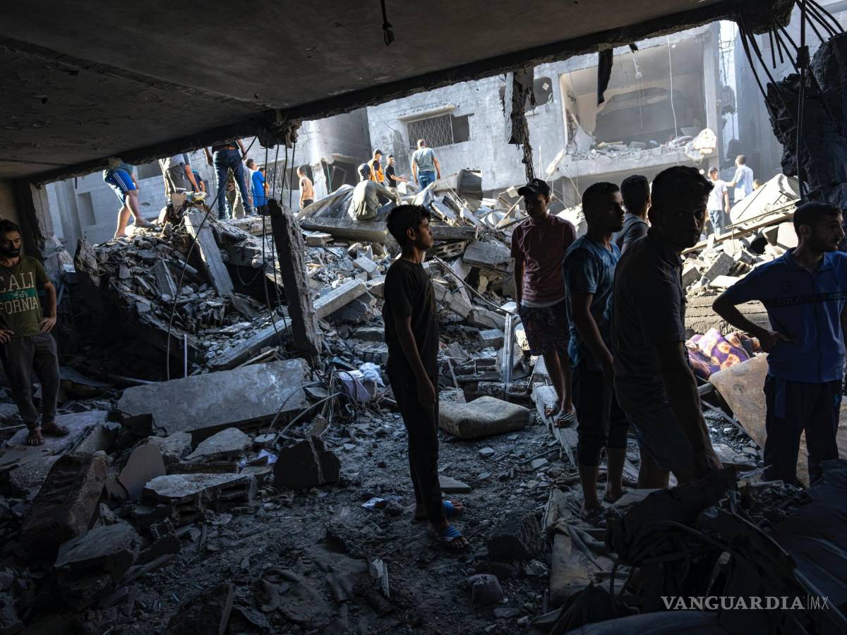 $!Palestinos buscan cadáveres y sobrevivientes entre los restos de un edificio residencial arrasado tras un ataque aéreo israelí sobre el campo de refugiados.