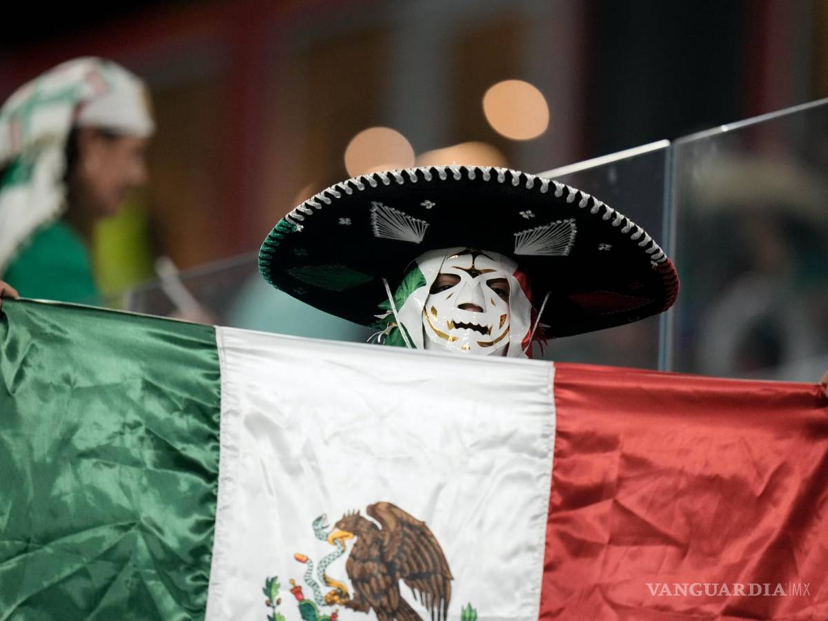 $!Un hincha mexicano sostiene su bandera nacional durante el partido de fútbol entre México y Polonia, en el Estadio 974 en Doha, Qatar.