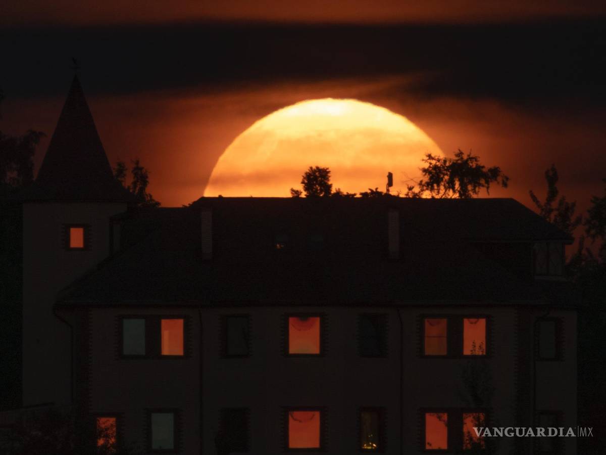 $!La luna llena, detrás de una casa en la localidad de Putilovo, a 70 kilómetros (43 millas) al este de San Petersburgo, Rusia, el 13 de julio de 2022.