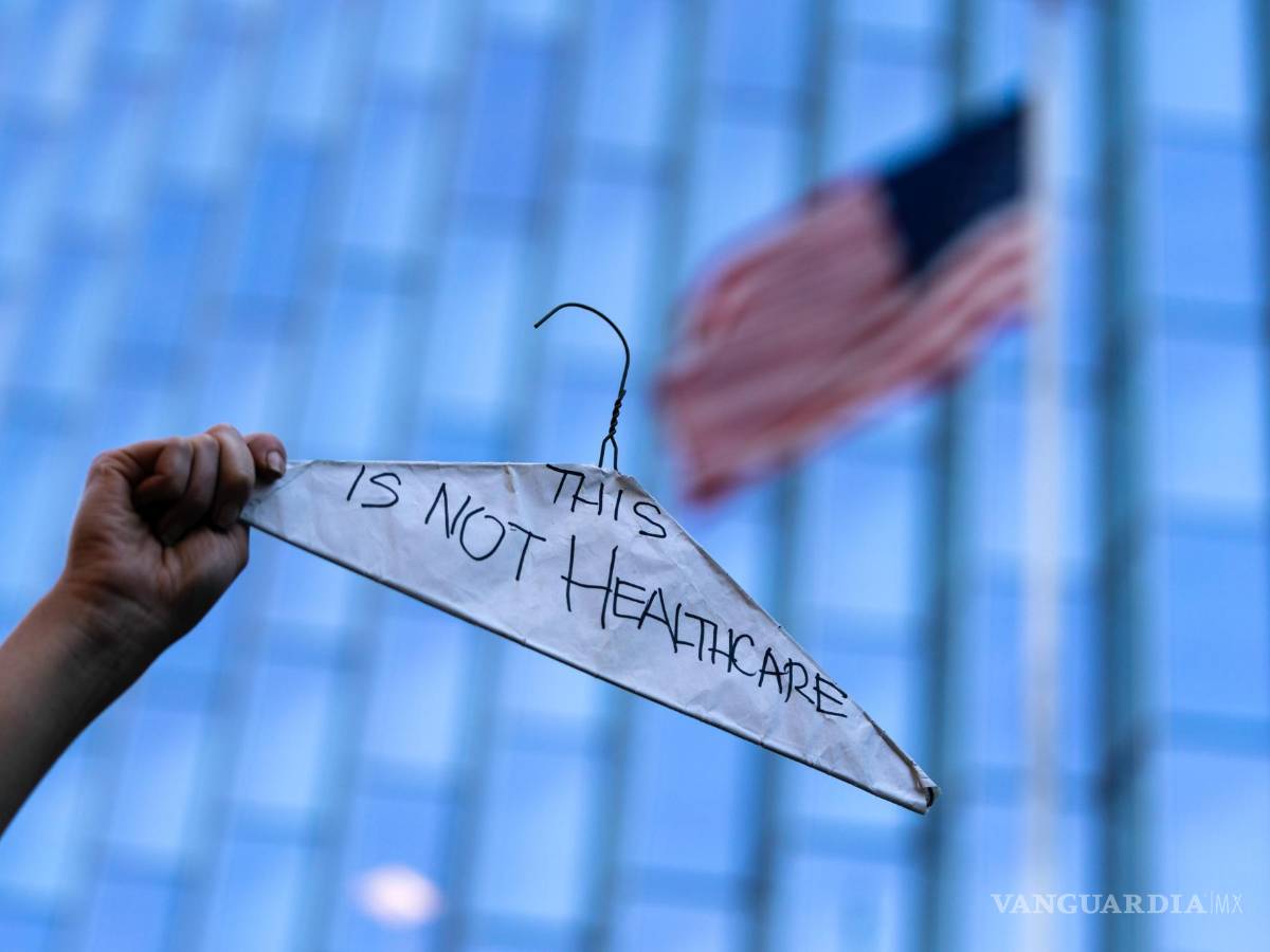 $!Una mujer sostiene un gancho de ropa para simbolizar los abortos ilegales y peligrosos en una protesta en pro del derecho en Los Ángeles.