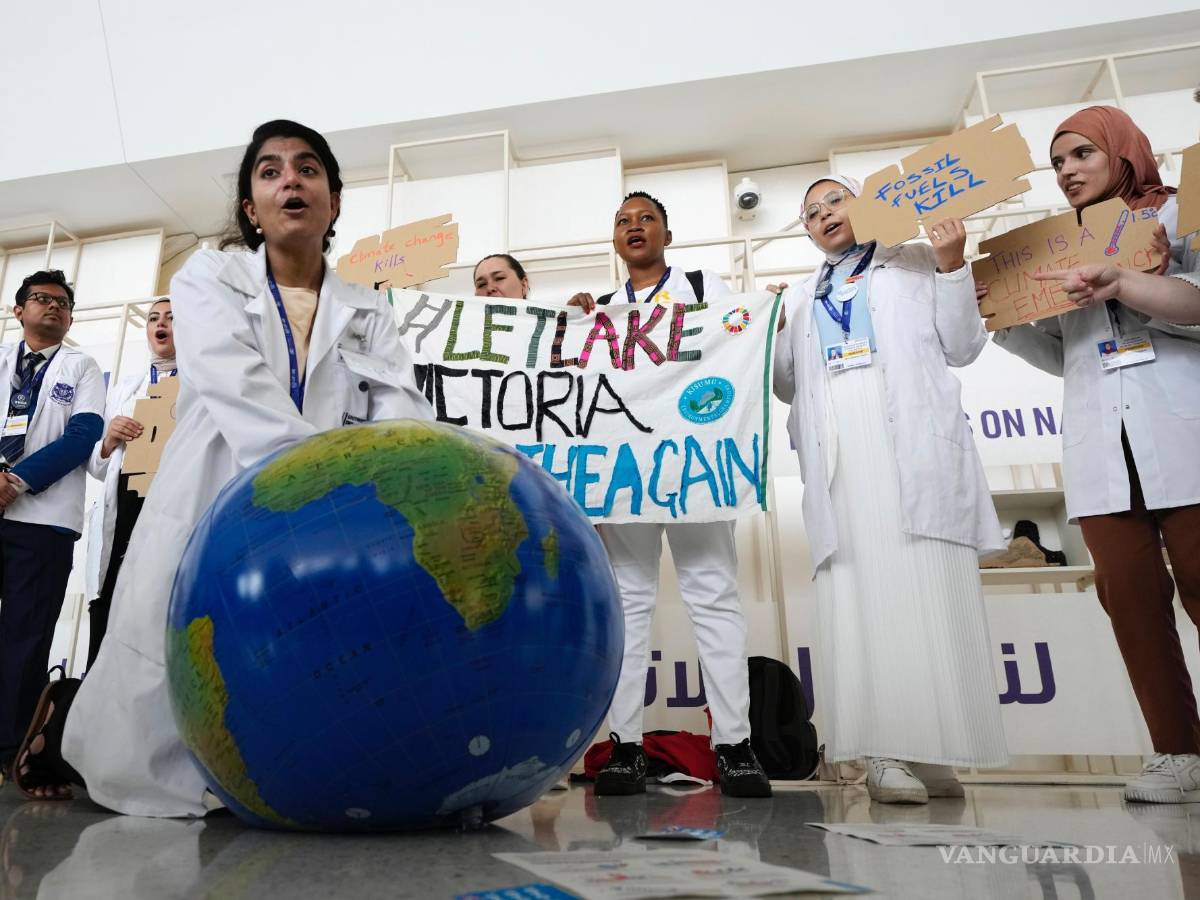 $!Una mujer simula reanimar al planeta Tierra durante una manifestación en la conferencia climática COP28 en Dubái, Emiratos Árabes Unidos.