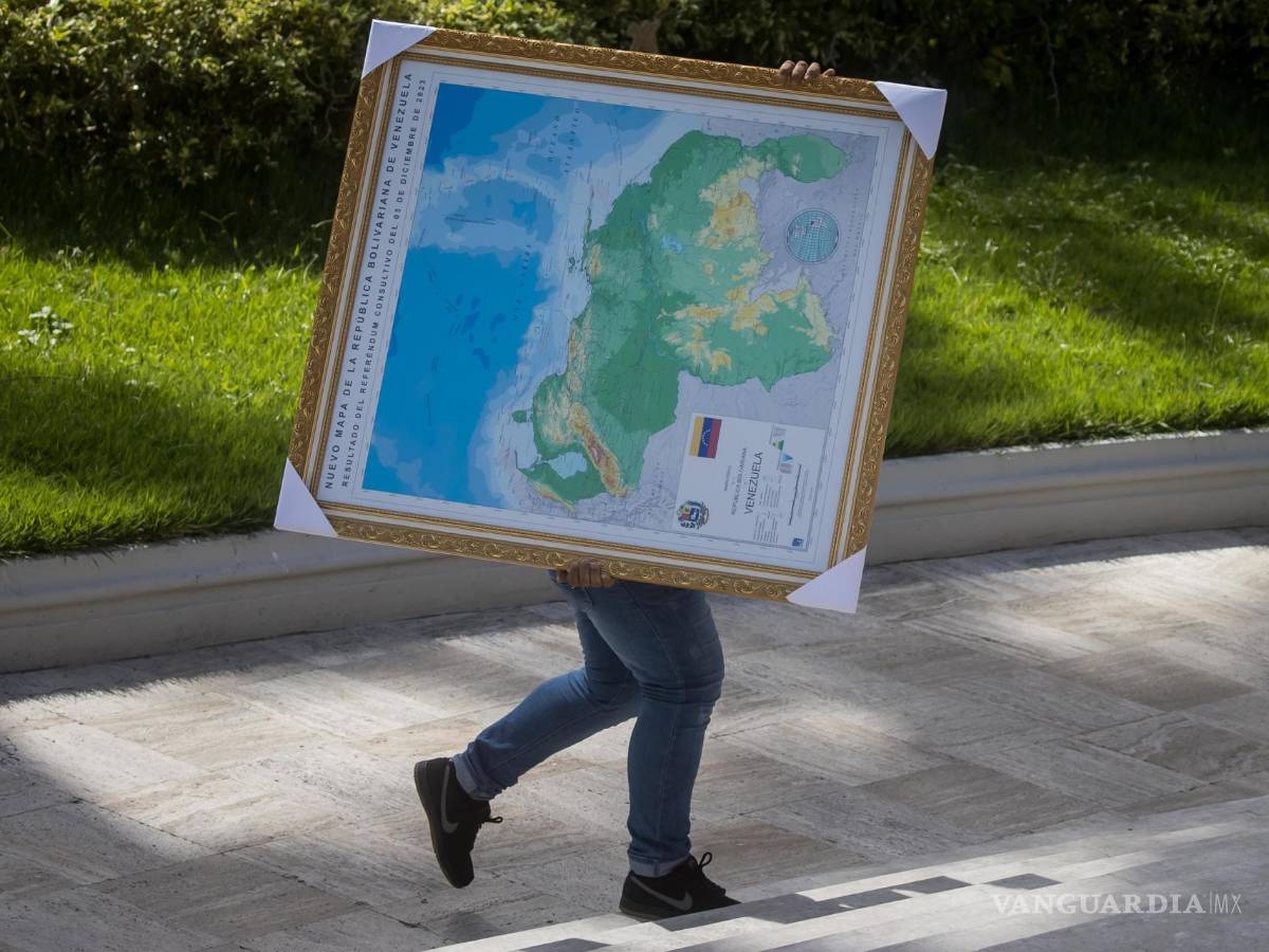 $!Un hombre carga un cuadro del mapa de Venezuela con la adhesión del Esequibo, en uno de los jardines del Palacio Federal Legislativo en Caracas, Venezuela.