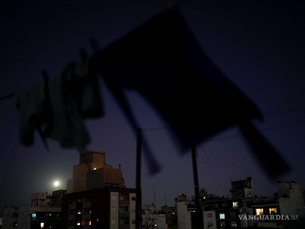 $!Ropa tendida para secarse en una terraza mientras la luna llena se eleva sobre Buenos Aires, Argentina, el miércoles 13 de julio de 2022.