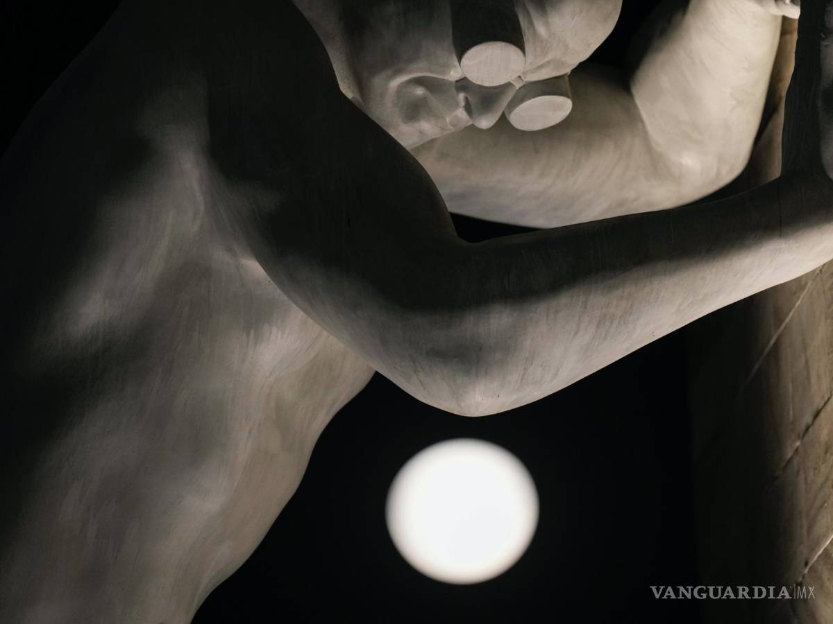 $!La luna llena, vista detrás de la escultura Mr Arbitrium, del artista Emanuele Giannelli, que se apoya en el Arco de la Paz, en Milán, Italia, el 13 de julio de 2022.