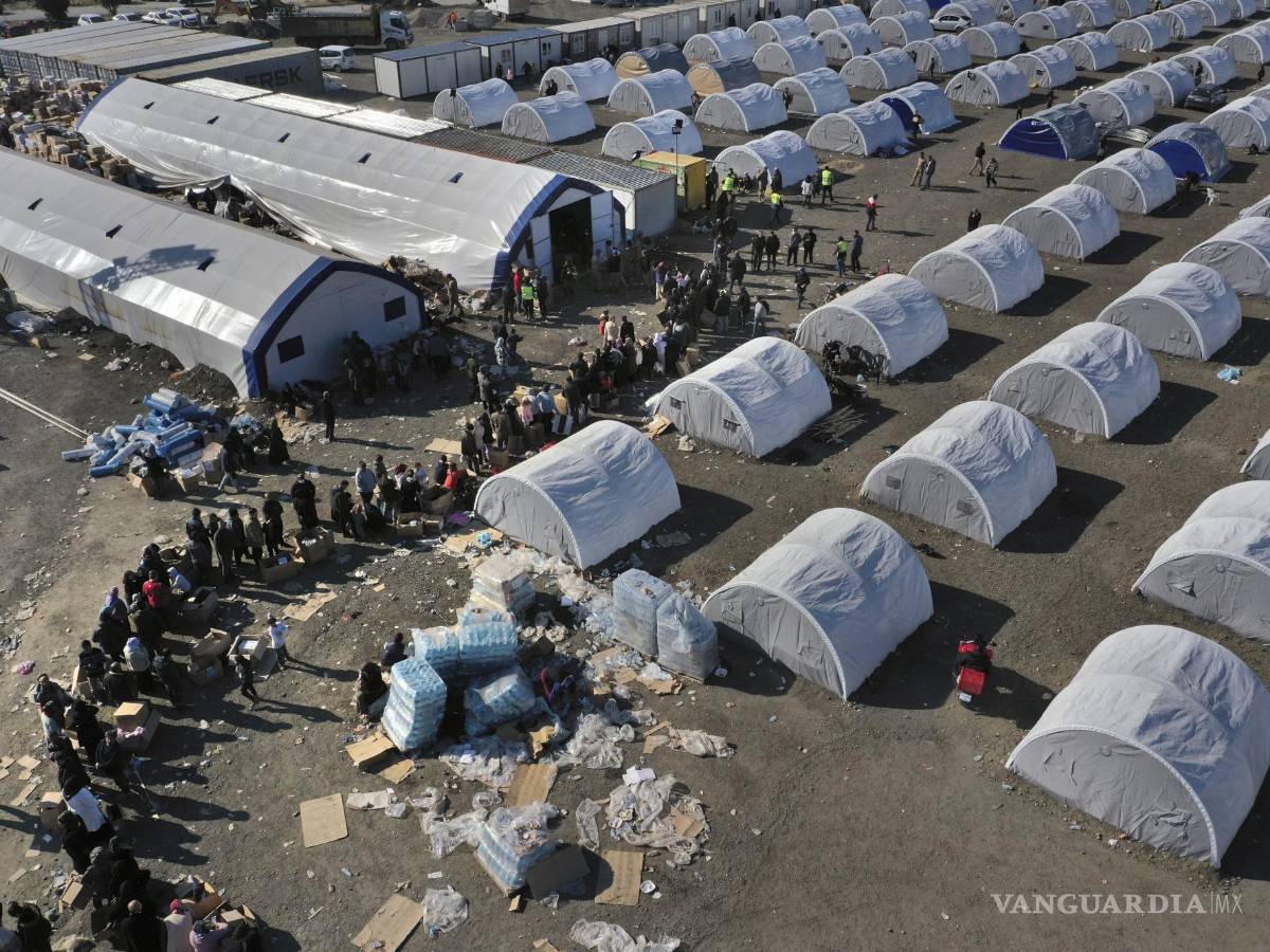 $!Personas que perdieron sus viviendas por un sismo devastador hacen fila para recibir víveres en un campamento improvisado, en Alejandreta.