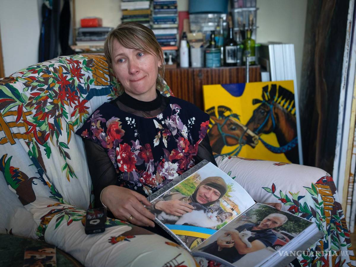 $!Yuliia Movchan, la esposa de un militar ucraniano que murió en batalla con las tropas rusas, muestra fotos de su esposo en un estudio de arte en Kiev, Ucrania.
