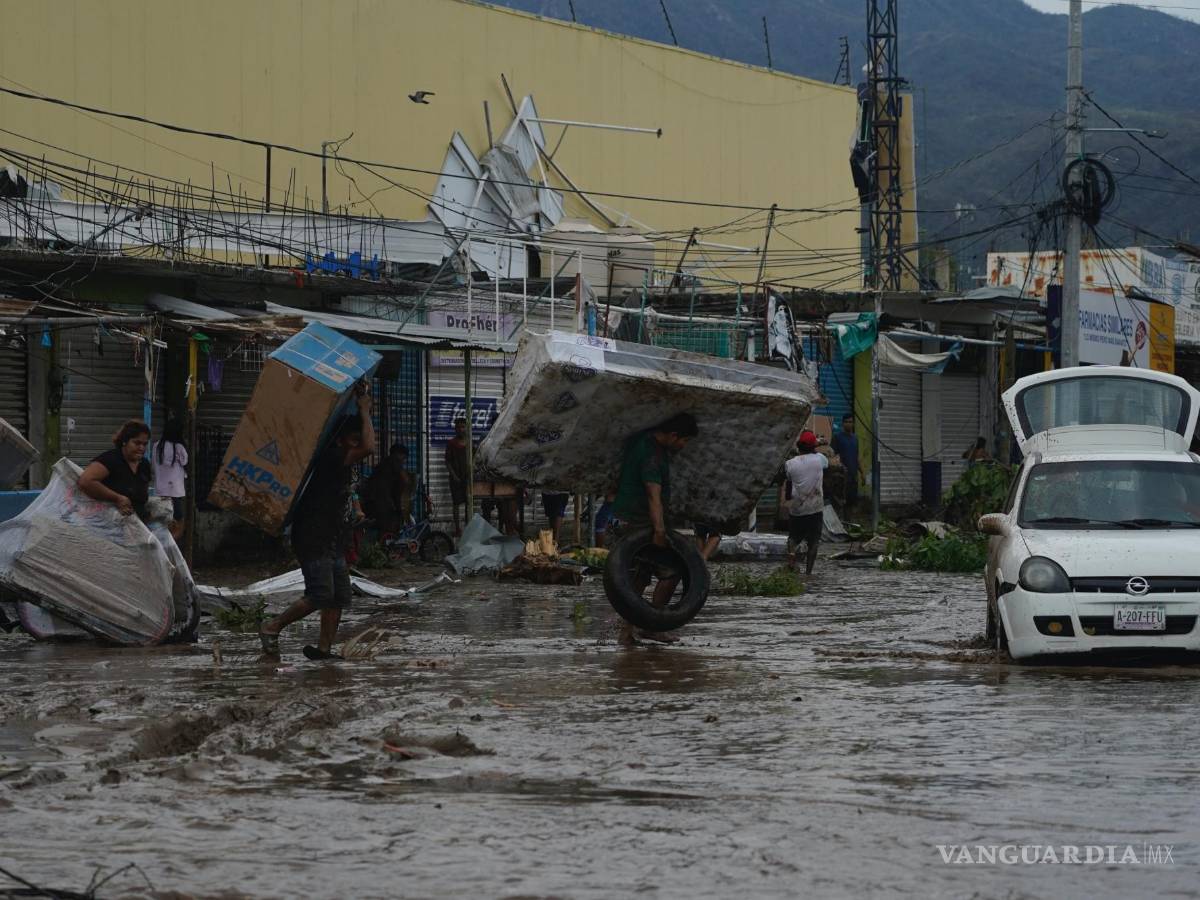 $!La gente camina con bienes saqueados de un centro comercial después de que el huracán Otis arrasara Acapulco, Guerrero (México).