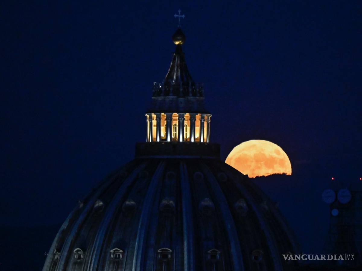 $!La Súper Luna llamada “Luna del Ciervo” se eleva en el cielo detrás de la cúpula de la Basílica de San Pedro en la Ciudad del Vaticano vista desde Roma, Italia.