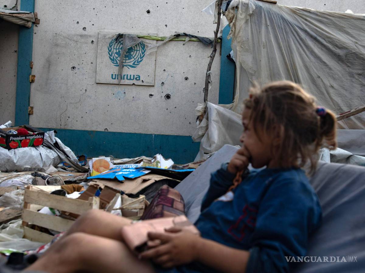 $!Una niña sentada junto a un logotipo de la UNRWA mientras los palestinos inspeccionan sus tiendas de campaña trasuna operación del ejército israelí.