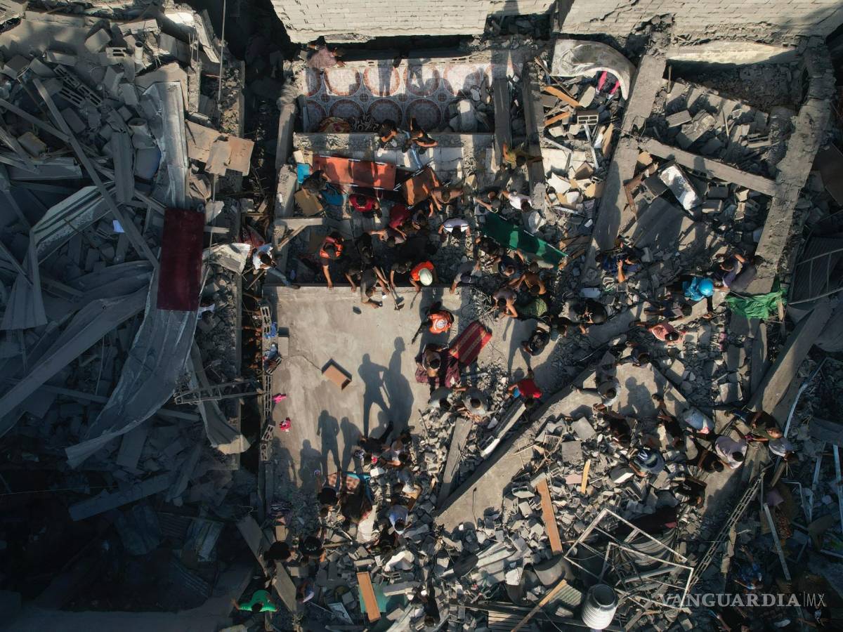 $!Palestinos inspeccionan los escombros de edificios alcanzados por un ataque aéreo israelí en el campo de refugiados Al Shati, el 12 de octubre de 2023.