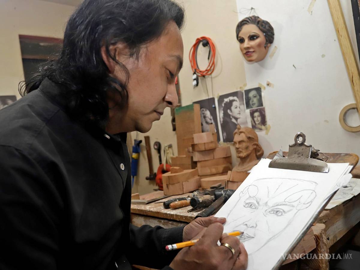 $!El escultor Adrián Becerra mientras trabaja en su taller de máscaras talladas en madera artesanal, en la ciudad de Puebla (México). EFE/ Hilda Ríos