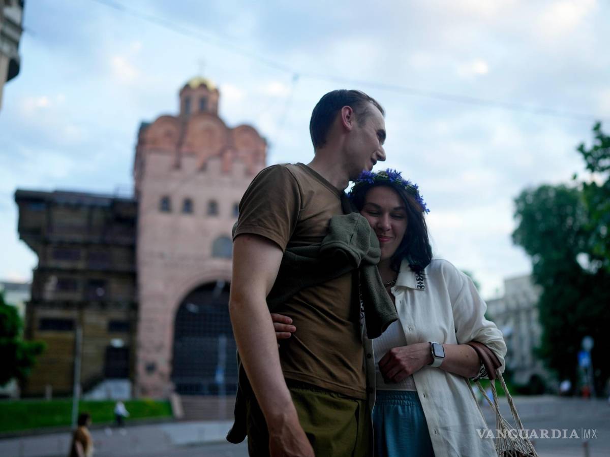$!Los cómicos de stand-up Serhiy Lipko y Anastasia Zukhvala se abrazan el día de su boda en Kiev, Ucrania.