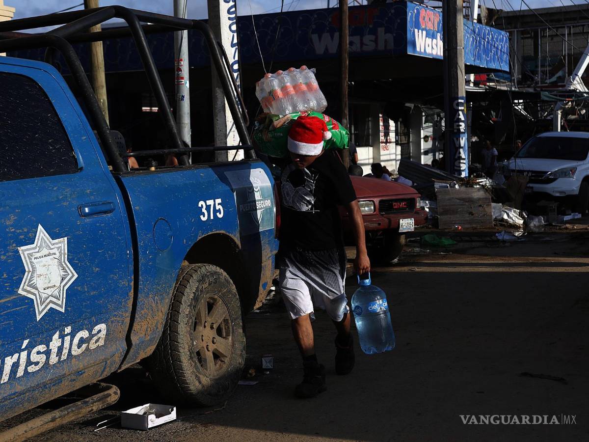 $!Fotografía que muestra a una persona mientras con objetos saqueados una tienda de autoservicio por el paso del huracán Otis en Acapulco, en Guerrero (México).