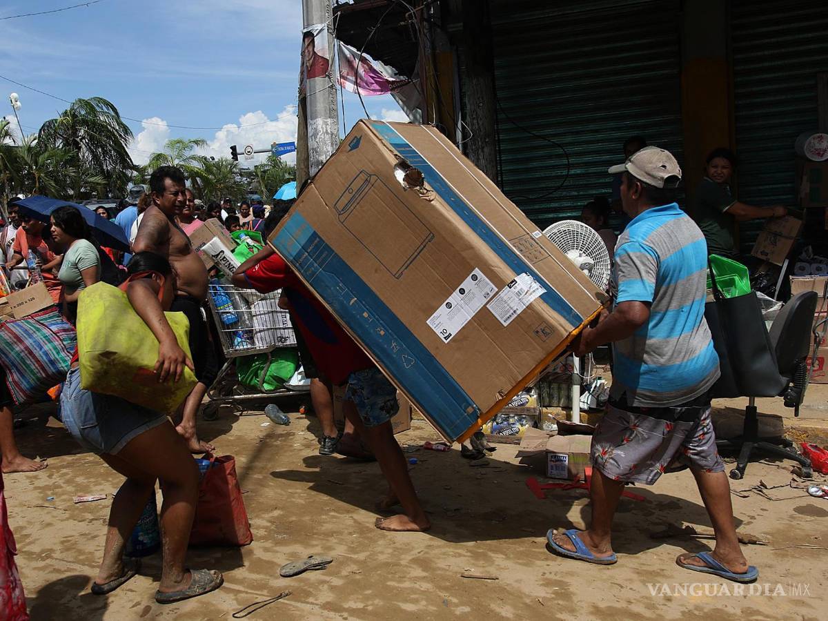 $!Fotografía que muestra personas mientras saquean tiendas de autoservicio por el paso del huracán Otis en el balneario de Acapulco, Guerrero (México).