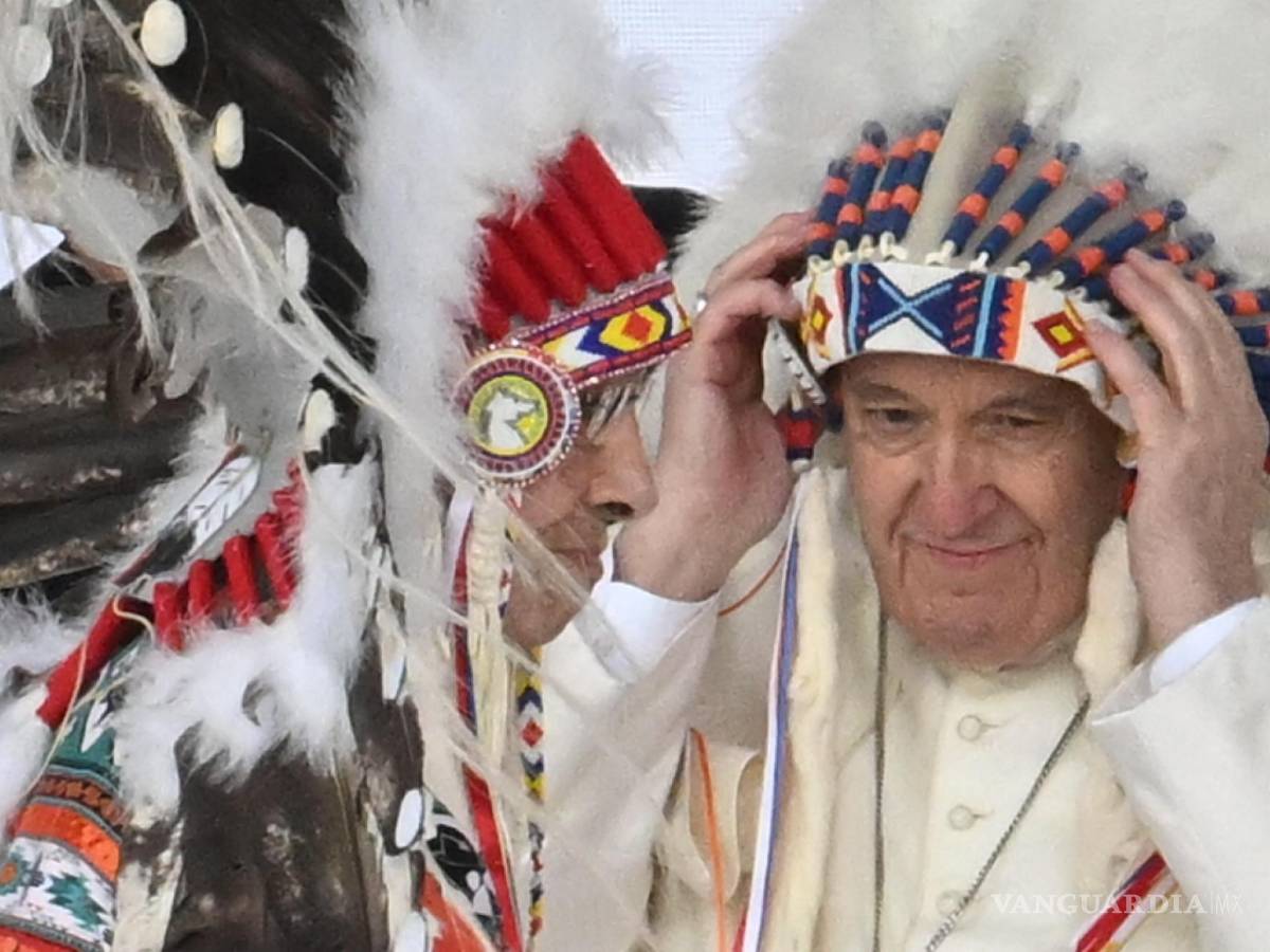 $!El Papa Francisco recibe un tocado indígena en una reunión con indígenas para una oración silenciosa en el cementerio de Maskacis en Edmonton, Canadá.