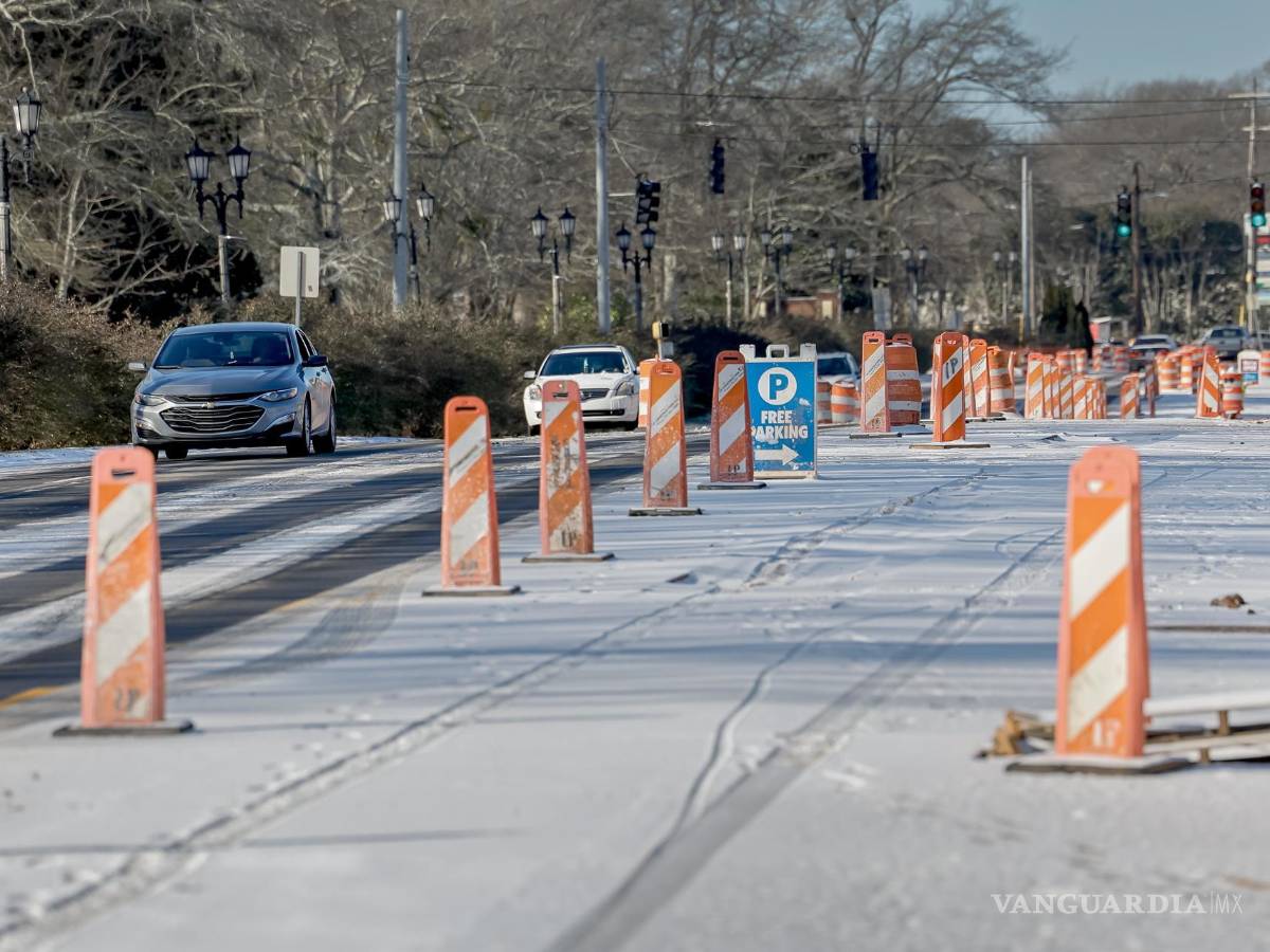 $!Un automovilista conduce por una carretera cubierta de nieve y hielo después de que cayeran al menos 12 milímetros de nieve en el área metropolitana de Atlanta.
