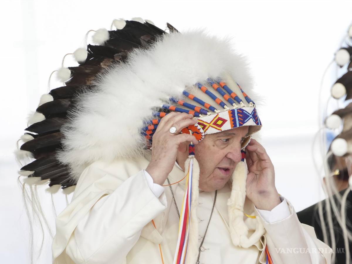 $!El papa Francisco se ajusta un tocado que le fue regalado después de ofrecer disculpas por el papel de la Iglesia católica enlos internados para niños indígenas.