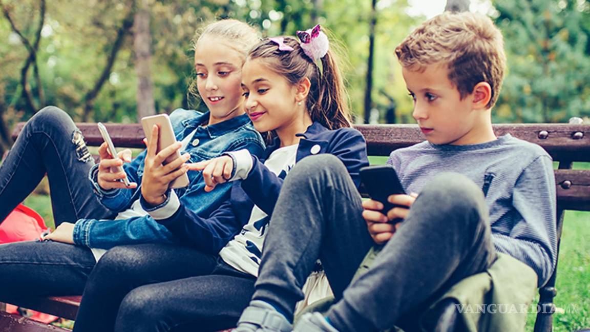 $!Grupo de niños con sus móviles al aire libre.
