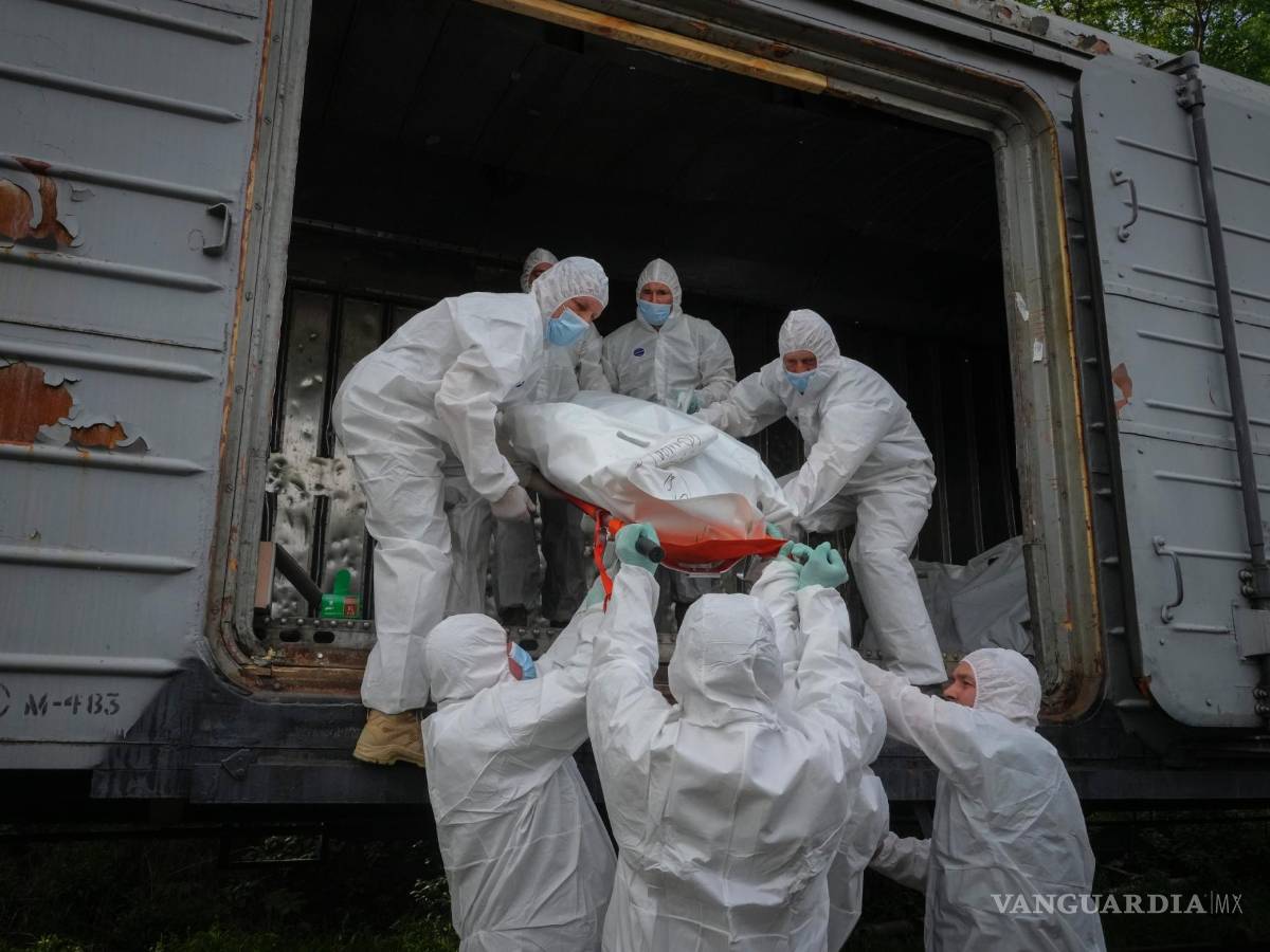 $!Soldados ucranianos cargan cuerpos de soldados rusos en un vagón frigorífico de ferrocarril en Kiev, Ucrania.