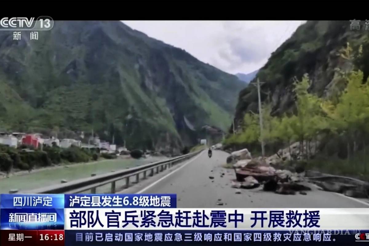$!Los residentes pasan junto a rocas caídas en una carretera en el condado de Luding, en la provincia de Sichuan, suroeste de China.