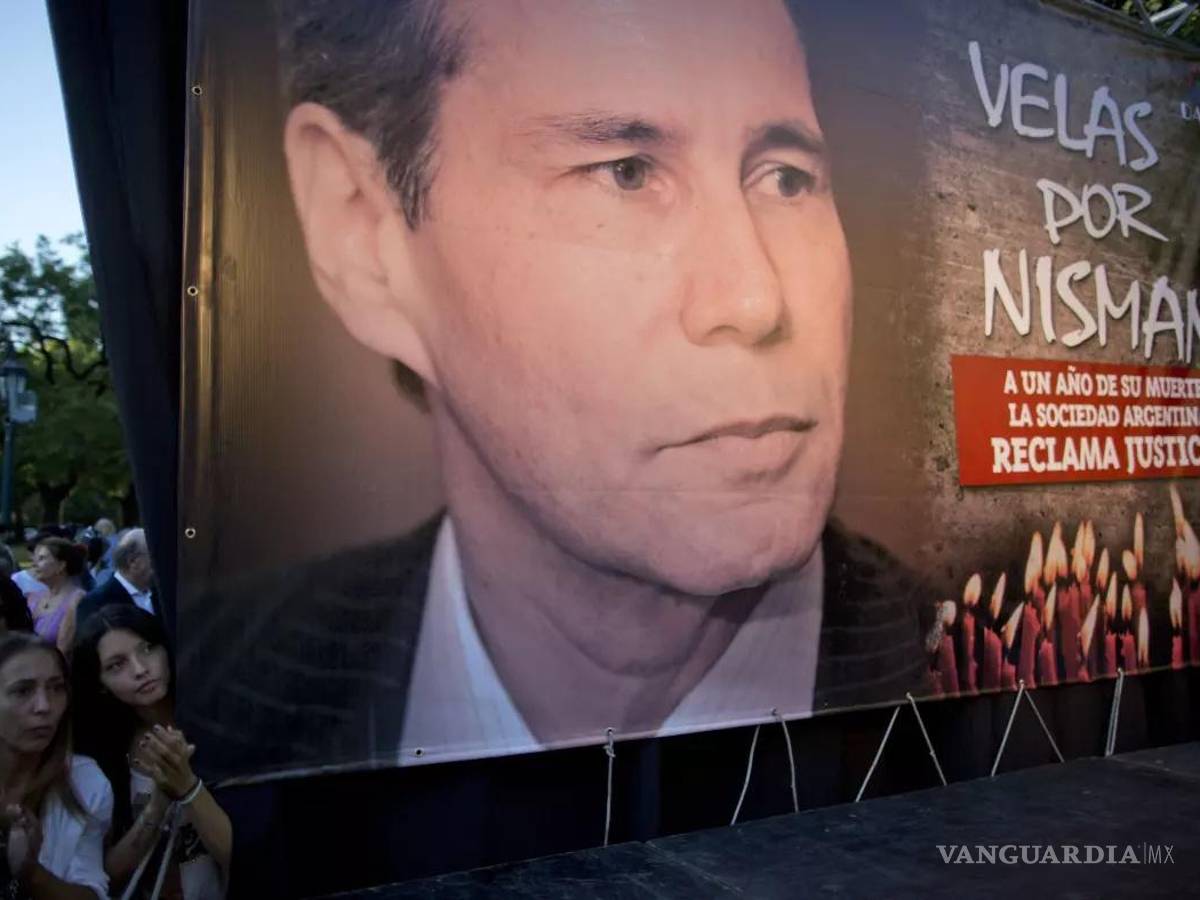 $!Fotografía del 18 de enero de 2016, mujeres se paran junto a una foto del difunto fiscal Alberto Nisman en el primer aniversario de su muerte en Buenos Aires.