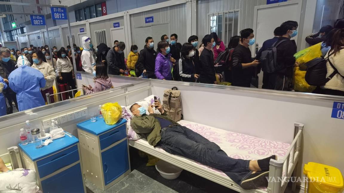 $!Las personas que dieron negativo al COVID-19 hacen fila para salir de un hospital temporal en Shanghái, China.