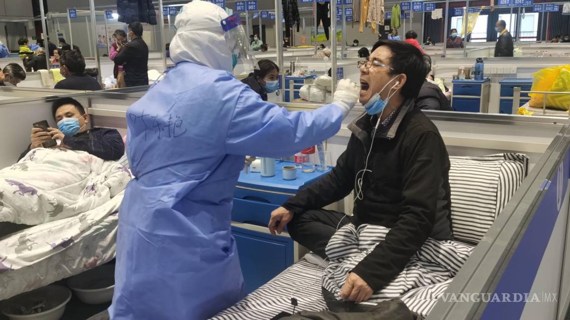 $!Una enfermera toman muestra de hisopos a un personas para la prueba de ácido nucleico en un hospital temporal para personas con COVID-19 en Shanghái, China.