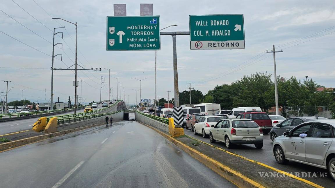$!Largas filas de vehículos quedaron atrapados debido al estancamiento de agua en el paso a desnivel.