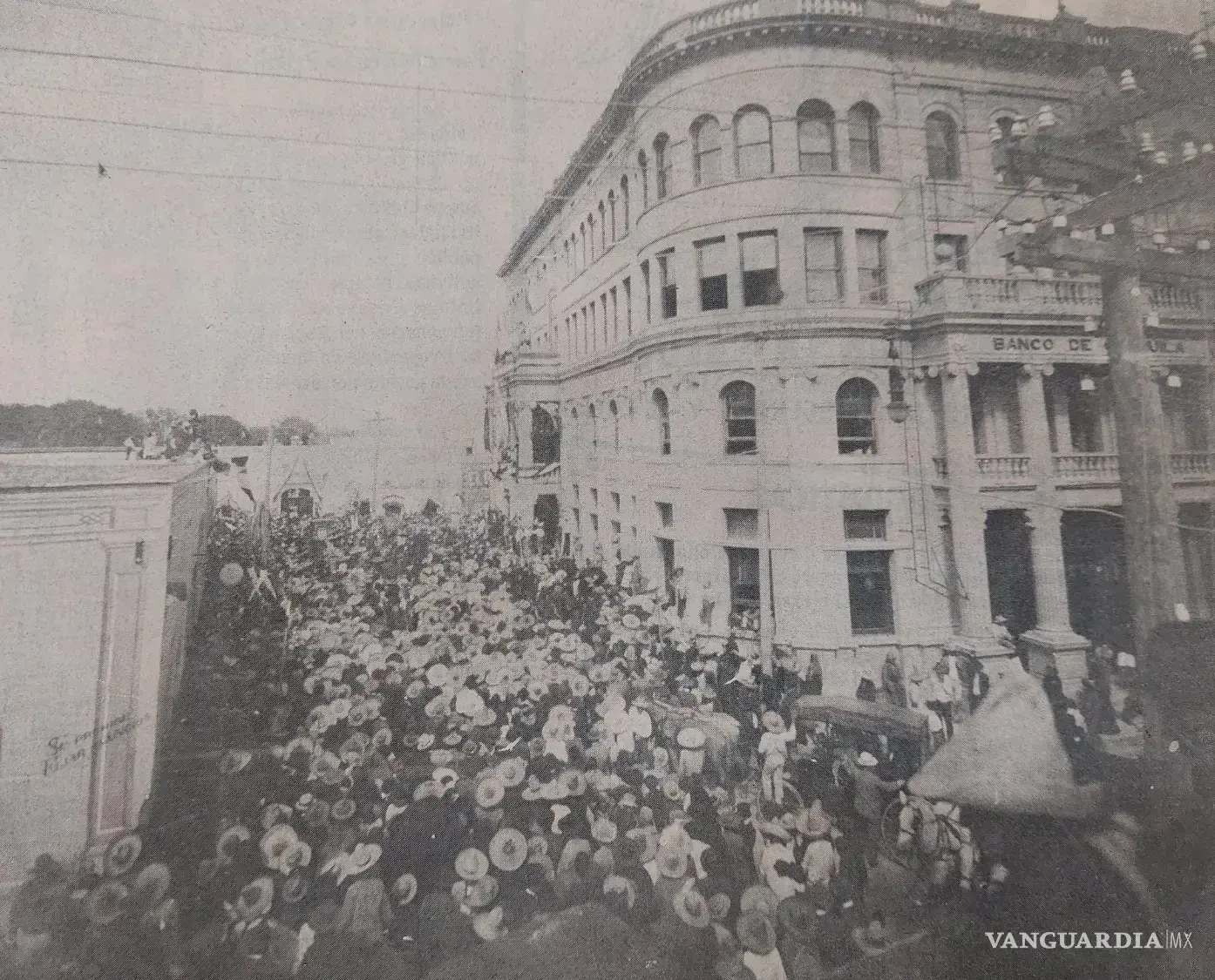 $!Una multitud se congrega frente al Hotel y Banco Coahuila para escuchar a Francisco I. Madero en 1910. Sobre los sombreros y las azoteas, los cables ya cruzaban el cielo de Saltillo. La modernidad eléctrica y la agitación política compartían escenario en una ciudad que comenzaba a transformar su paisaje.