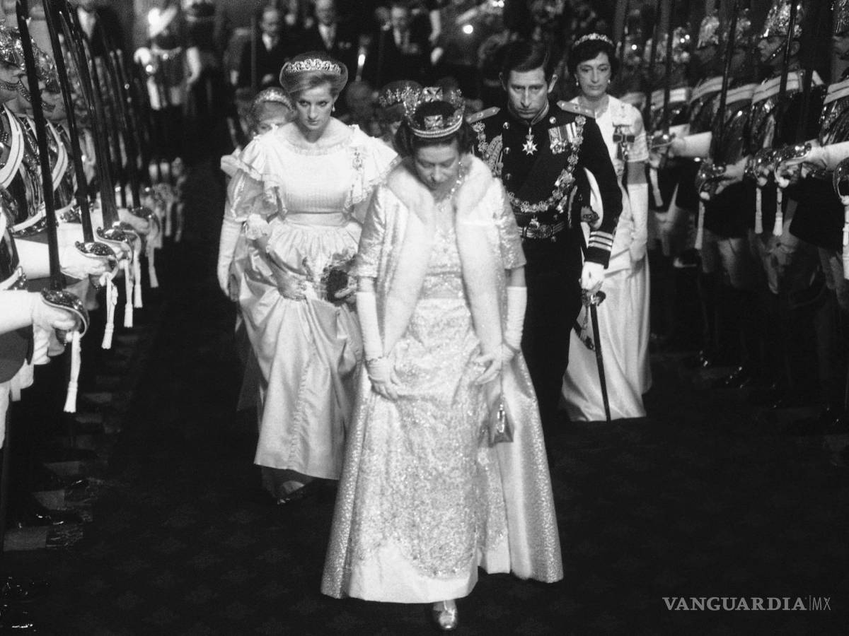 $!La reina Isabel II de Gran Bretaña es seguida por la princesa Diana y el príncipe de Gales Carlos a su llegada al Parlamento el 6 de noviembre de 1984. AP/Bob Dear