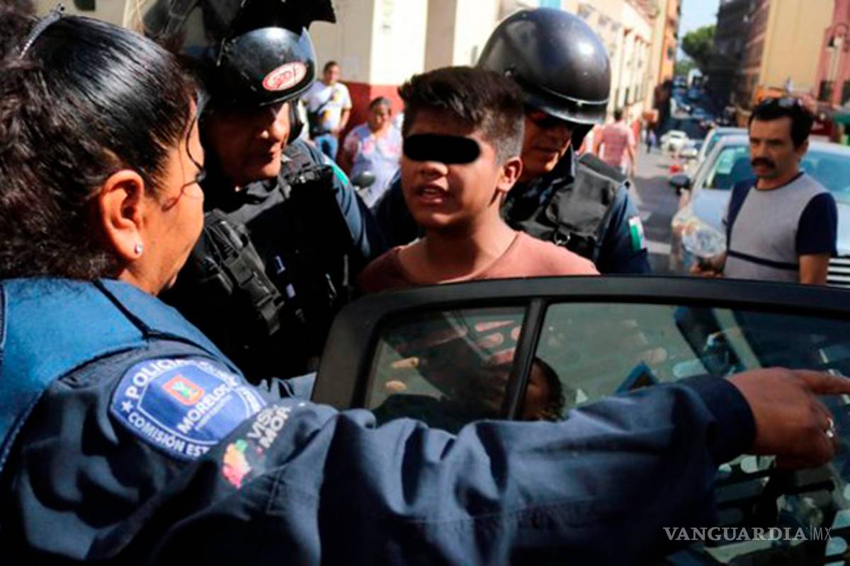 Policías despiertan a menor que dormía en la banqueta a patadas; se lo llevan esposado