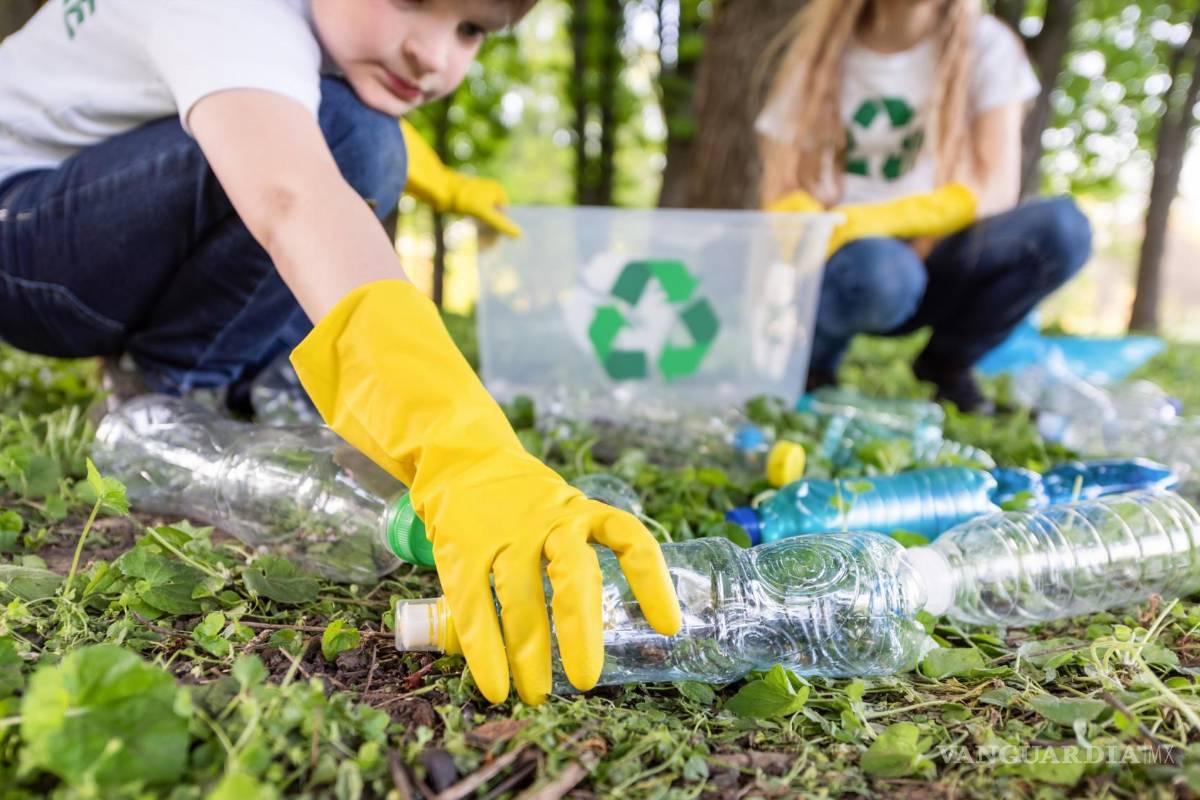 $!Niña y niño recolectan basura plástica en un parque para ser reciclada.