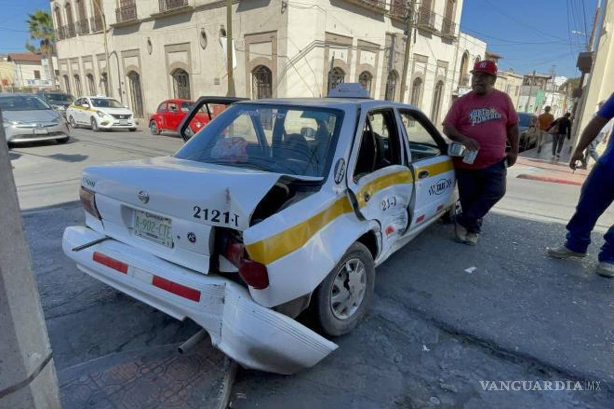 $!El impacto de la camioneta Chevrolet Tracker contra el taxi Nissan Tsuru dejó a la pasajera con lesiones, mientras que el vehículo terminó estrellado contra un poste.
