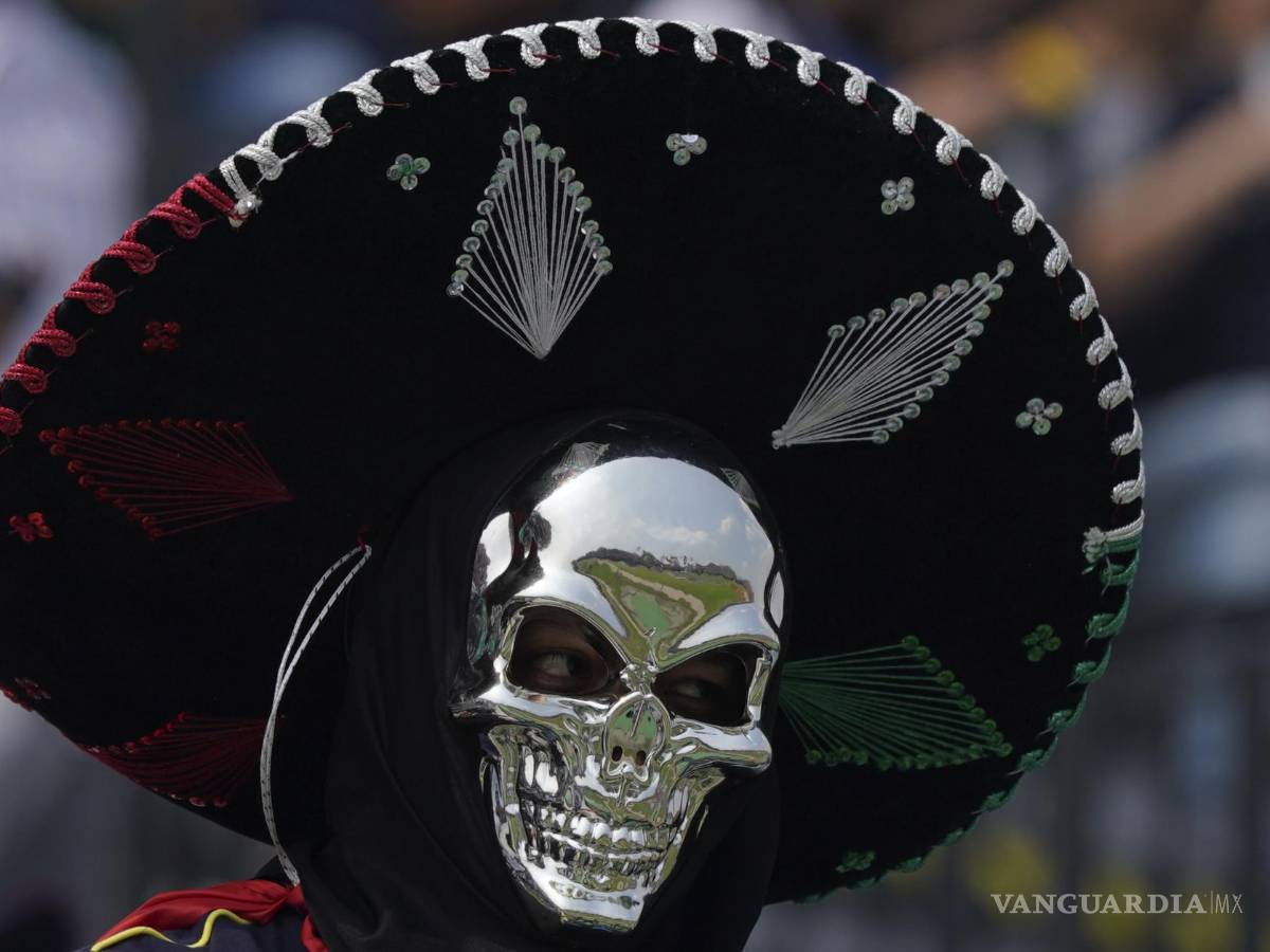 $!Un aficionado con una máscara de calavera plateada y un sombrero de charro aplaude antes del inicio de la carrera de autos del Gran Premio de México.