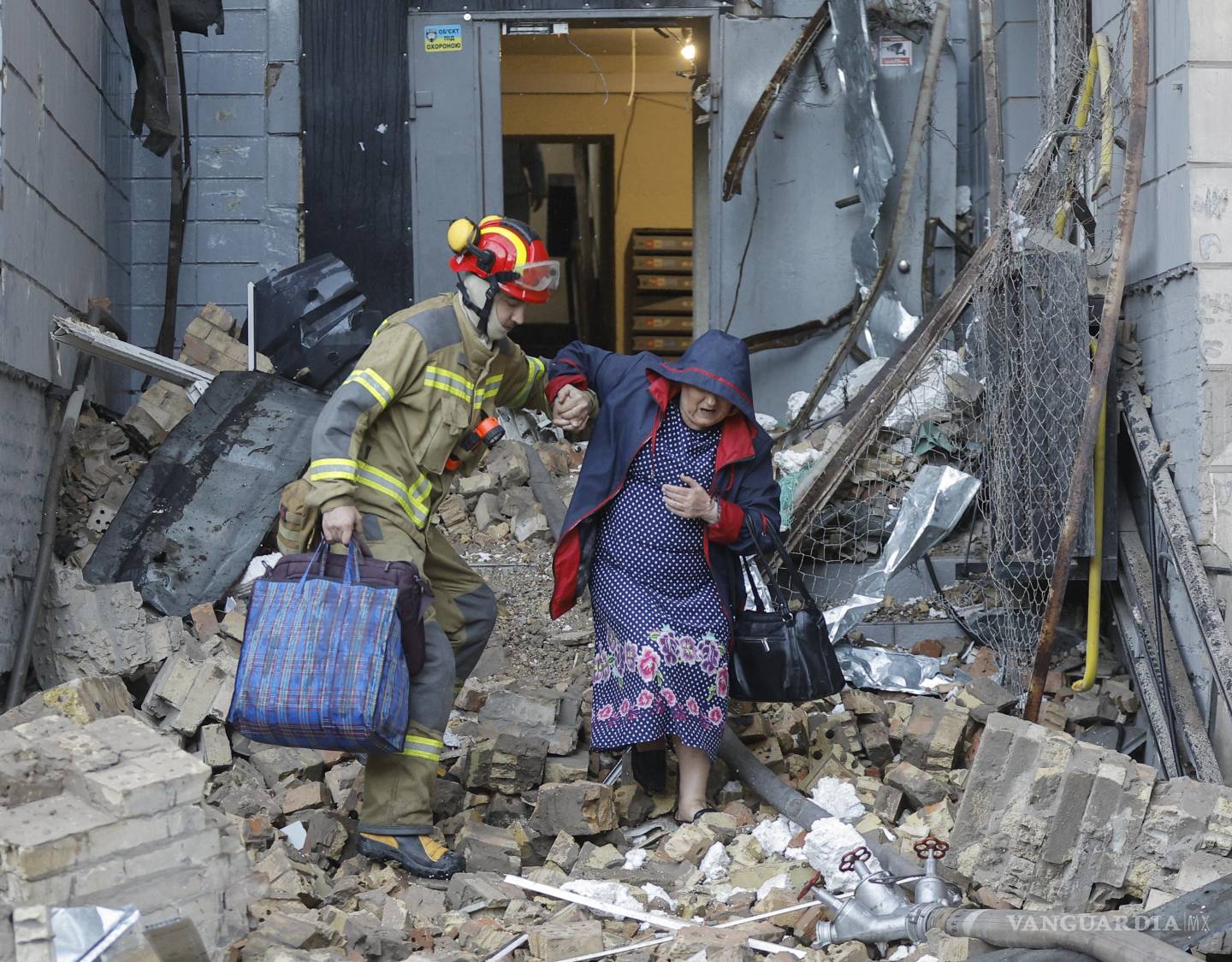 $!Un rescatista ayuda a una mujer local en el lugar de un ataque con misiles rusos contra una zona residencial de Kiev, Ucrania, el 20 de agosto de 2026.