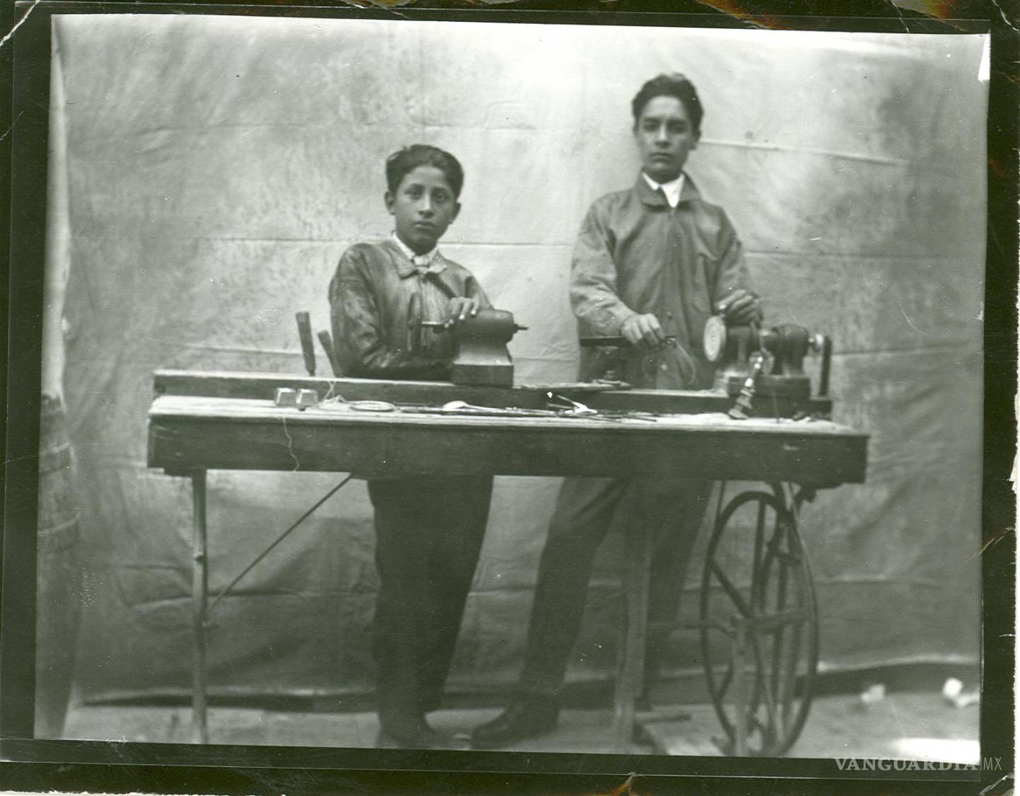 $!Felipe de Jesús Granada Valero, de 15 años y un compañero en su taller, frente al primer torno que le regaló su padre.