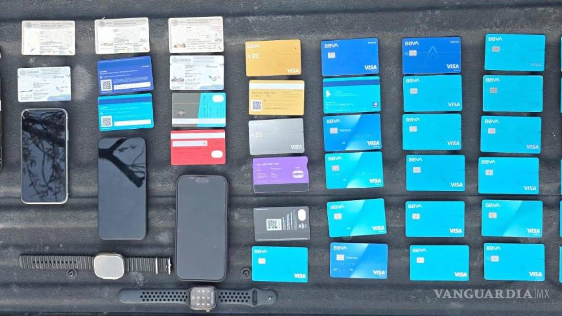 $!Elementos revisan a los cuatro detenidos, quienes portaban más de 30 tarjetas bancarias.