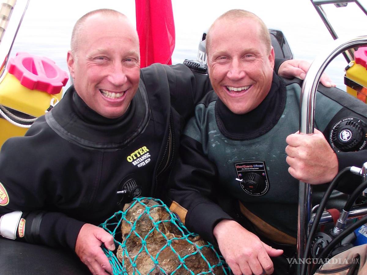 $!Julian y Lincoln Barnwell posan para una foto con la campana del HMS Gloucester, encontrada en 2007.