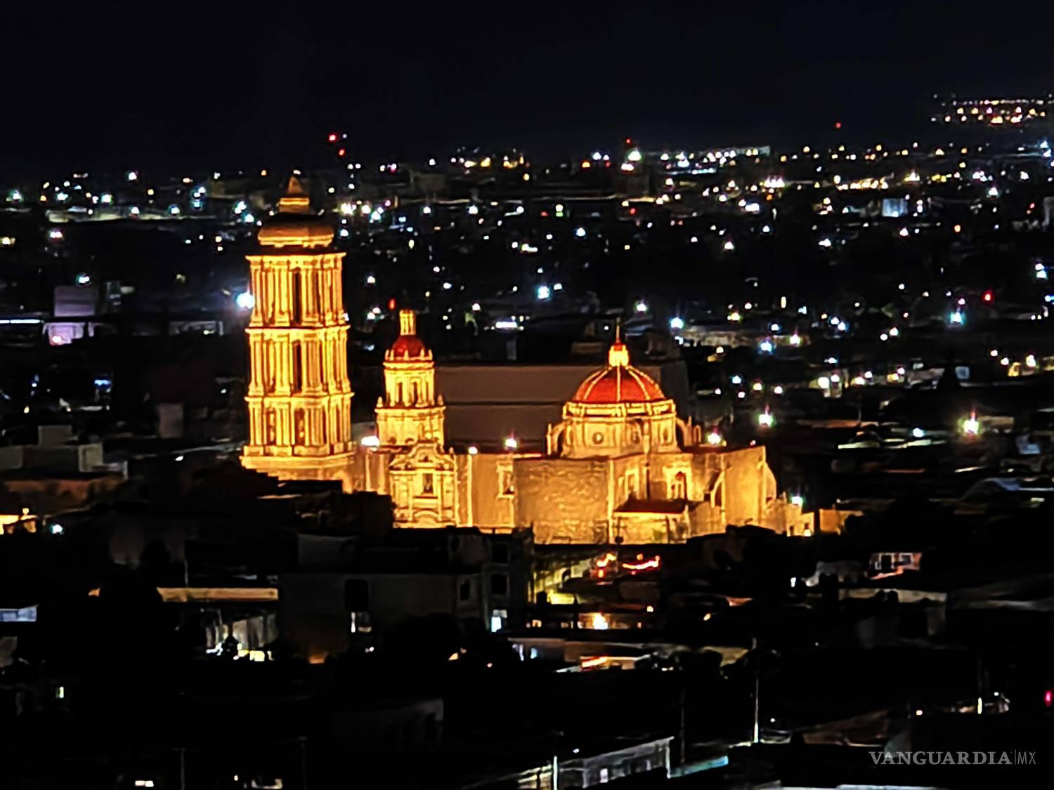 $!Desde el Mirador de Saltillo, visitantes capturan la vista nocturna de la ciudad mientras una ligera llovizna acompaña el momento.