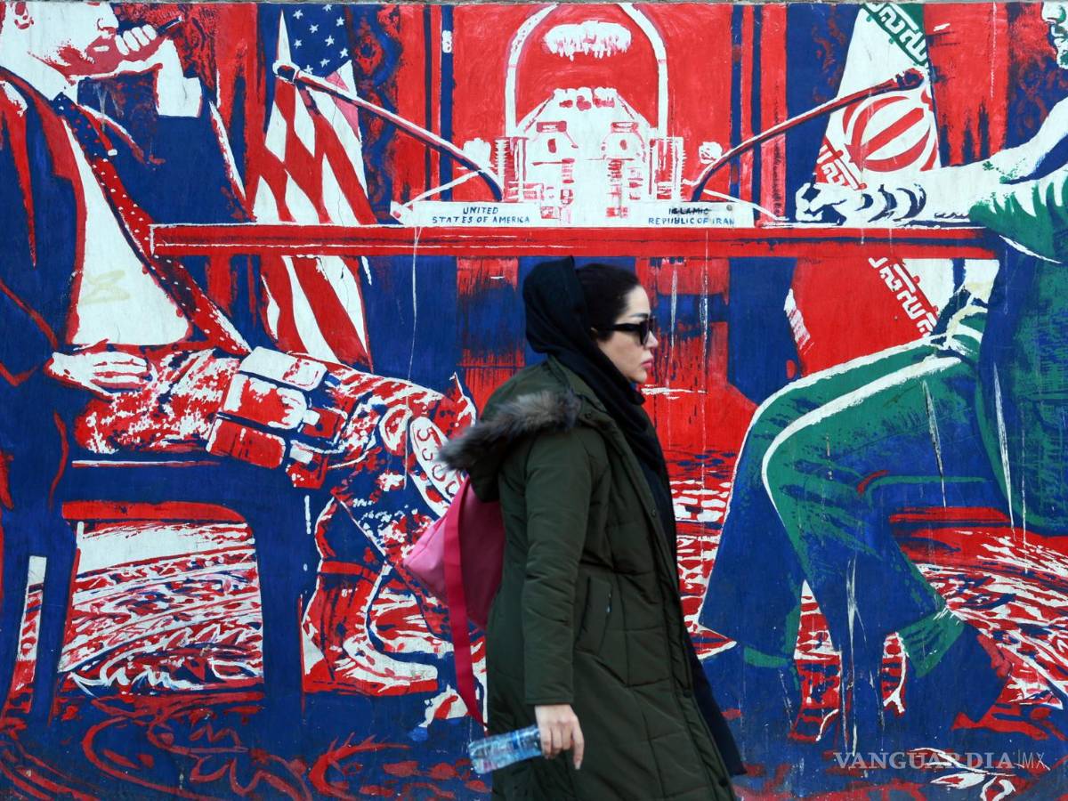 $!Una mujer iraní pasa junto a un mural antiestadounidense cerca de la antigua embajada de Estados Unidos en Teherán.