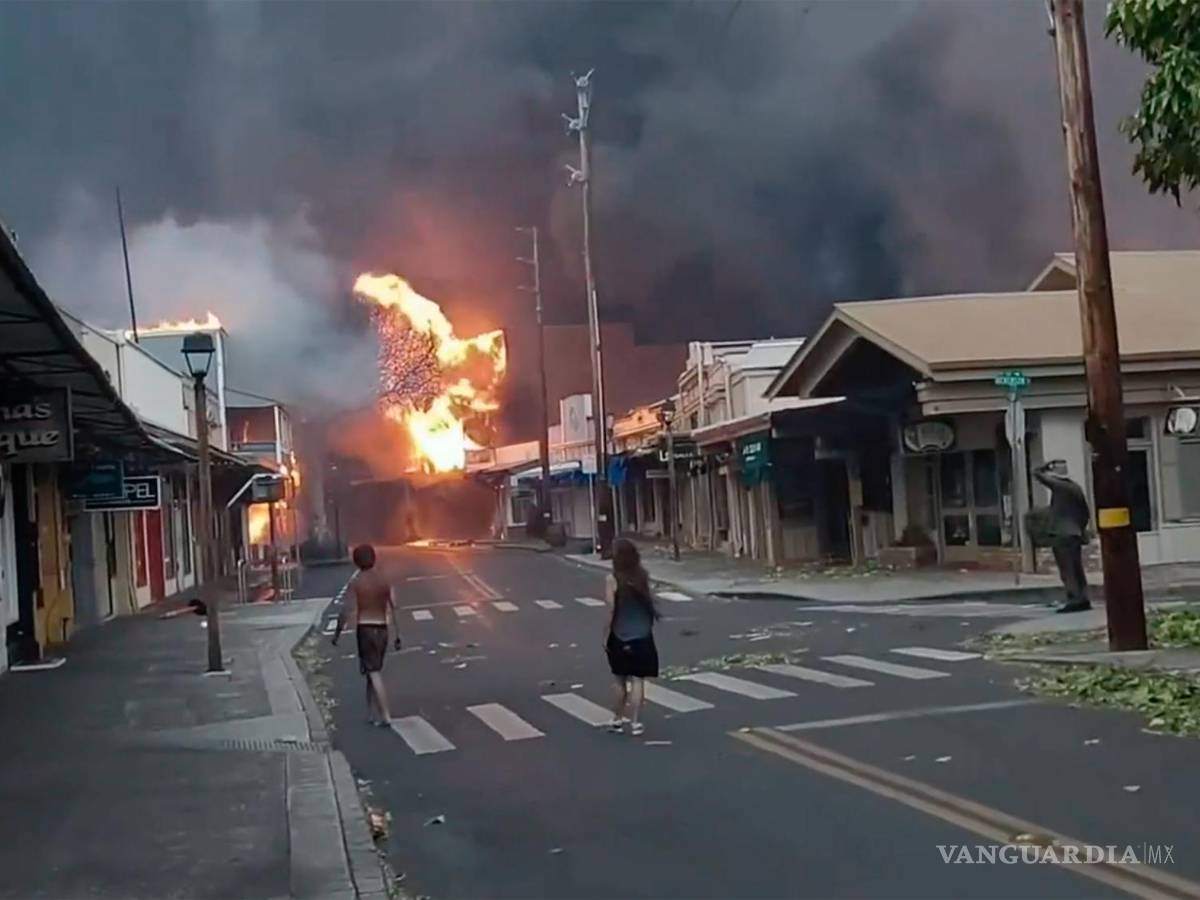 $!La gente observa cómo el humo y las llamas llenan el aire de los incendios forestales en Front Street en el centro de Lahaina, Maui en Hawái.