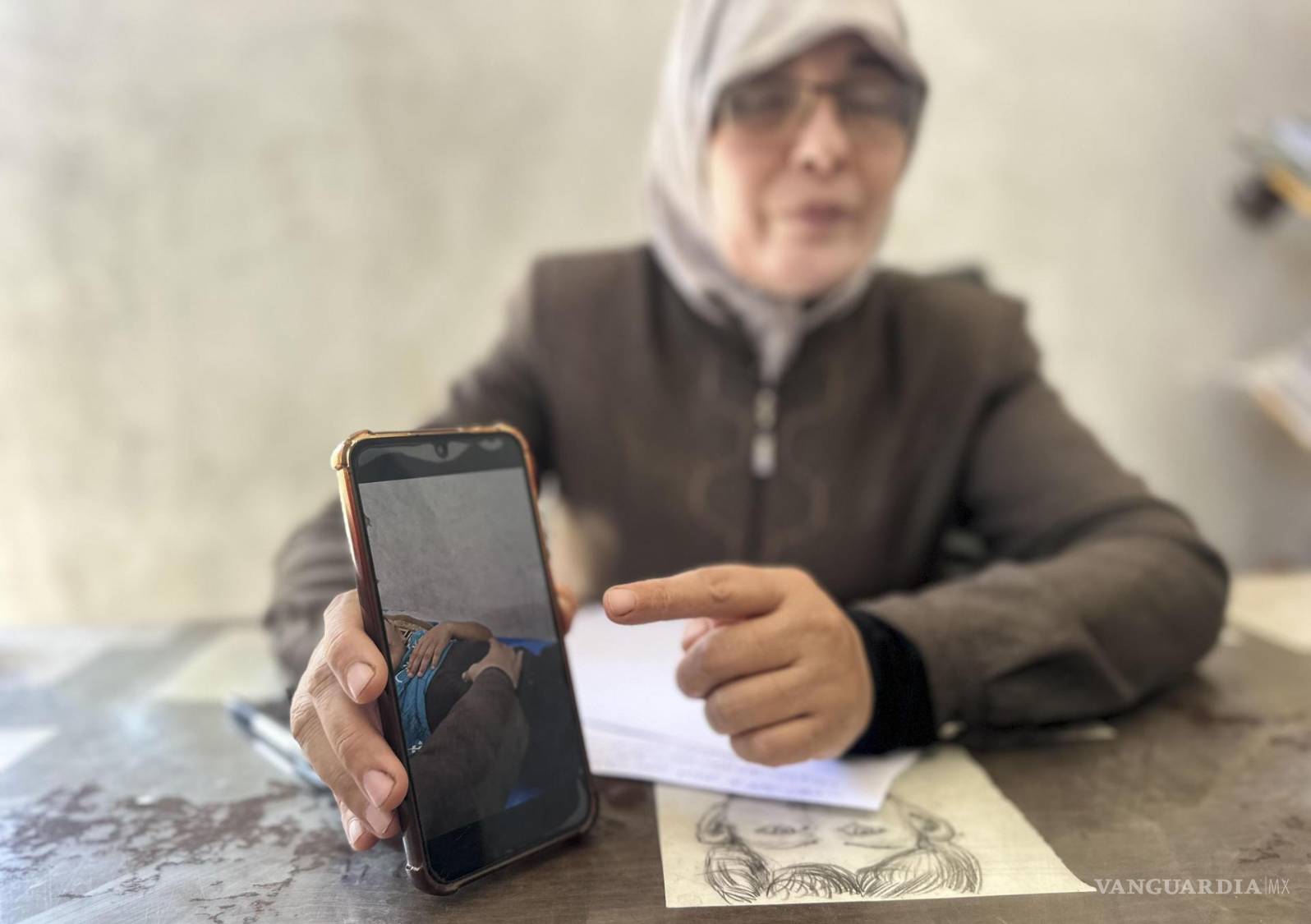 $!ALa terapeuta Nawal Asqul muestra en su teléfono el tratamiento que realiza a os niños que sufren por el trauma de la guerra en Al Mawasi, Franja de Gaza.