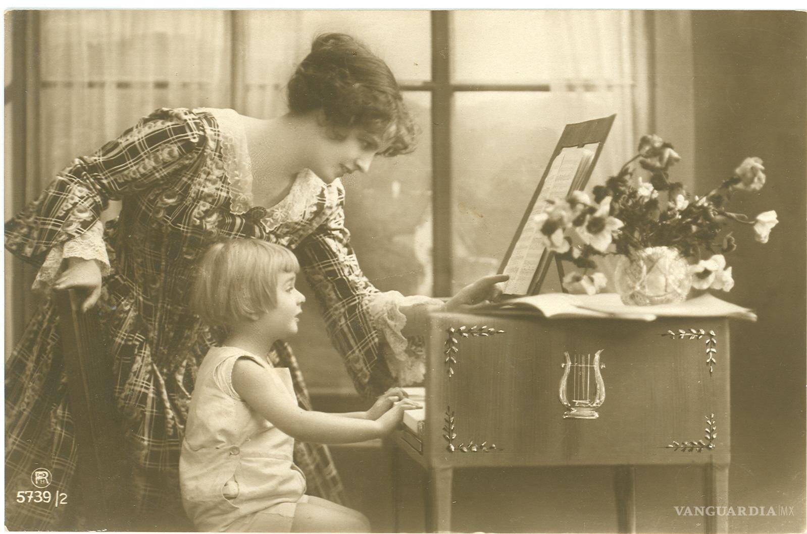 $!La imagen muestra una escena entre quienes probablemente sean madre e hija frente a un piano. En el reverso, a letra cursiva se lee: “Mi nena: acuérdate de mí cuando estés triste, cuando tu alma solitaria llore, cuando quieras tener quien te consuele, cuando busques una alma que te adore”. Fechada el 10 de diciembre de 1920 con una firma que parece aludir a un M. Santillán, la postal remata con un “No me olvides, nena”.
