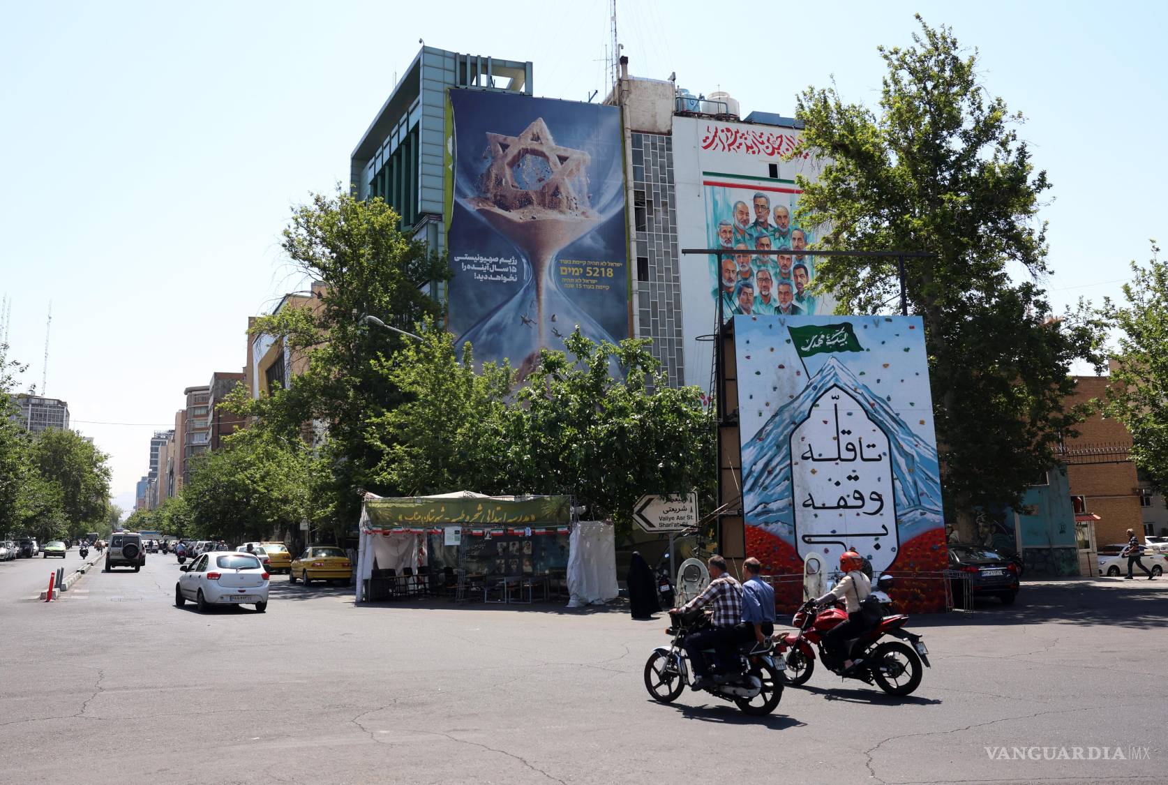 $!Conductores iraníes pasan en coche junto a una valla publicitaria antiisraelí con la frase en persa: «Israel no verá los próximos quince años», en la Plaza Palestina de Teherán, Irán.