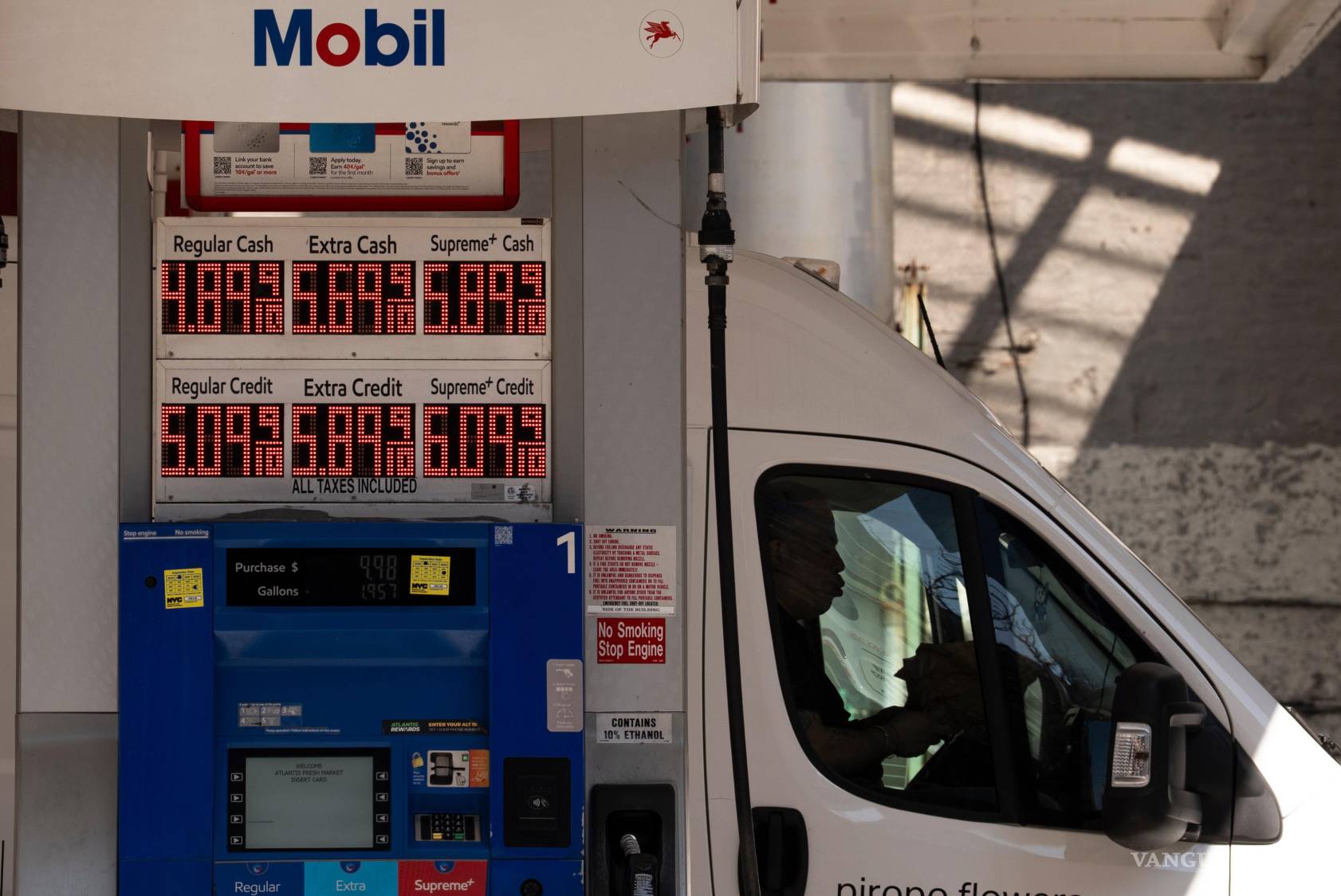 $!Una persona sentada en un coche como cartel que muestra el precio de la gasolina en una gasolinera, el martes 10 de marzo de 2026, en Nueva York.