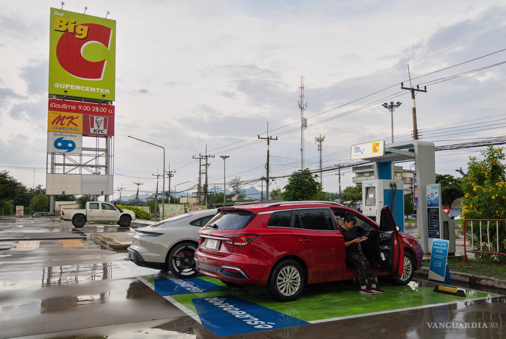 $!Chanakan Sa-Nguanslip espera a que se cargue su vehículo eléctrico de fabricación china en una gasolinera de Kanchanaburi, Tailandia.