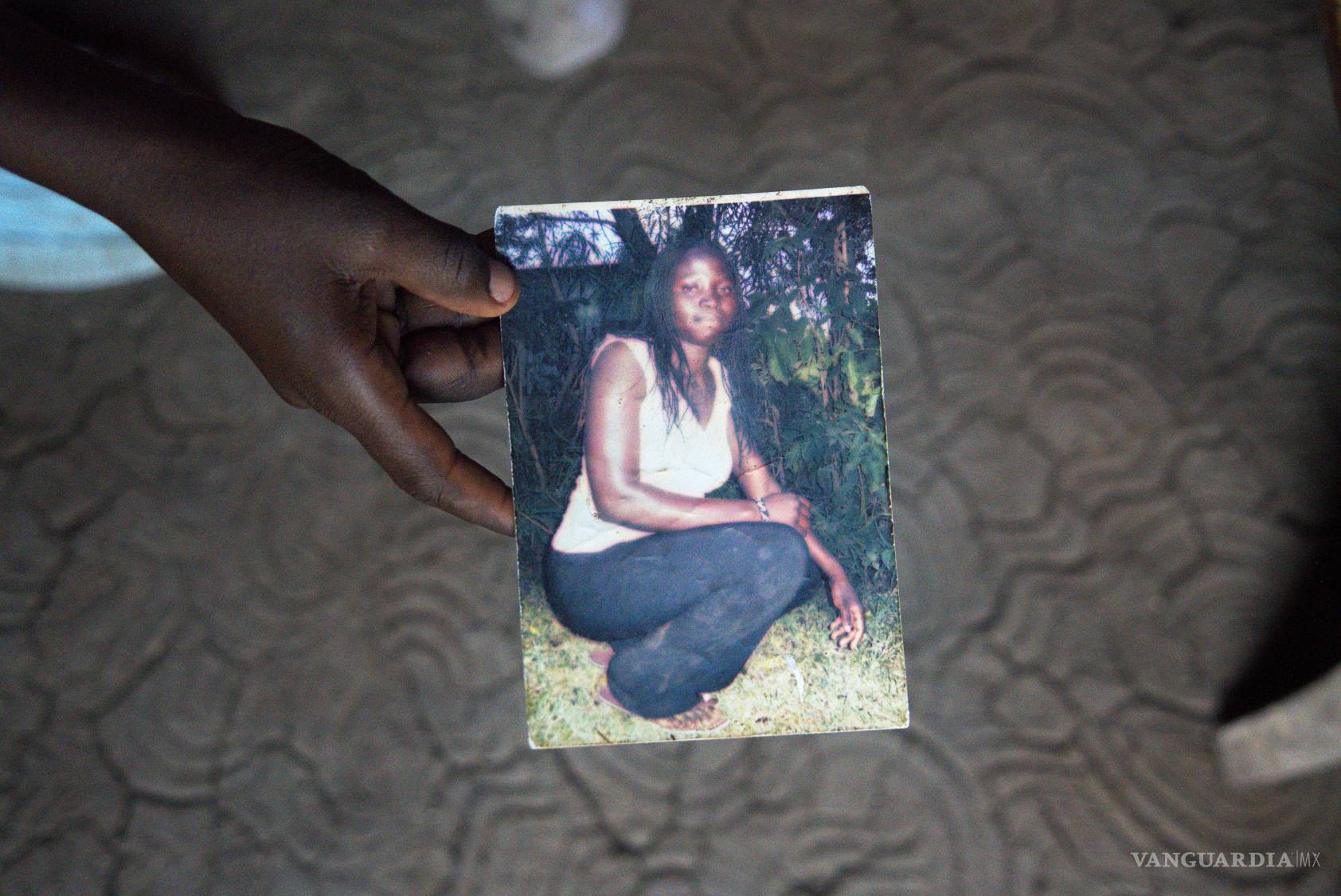 $!El hijo de Mary Olouch, quien murió a los 25 años tras un aborto mal practicado, sostiene una foto de ella en su casa en Karabok, Kenia, el 20 de julio de 2025.