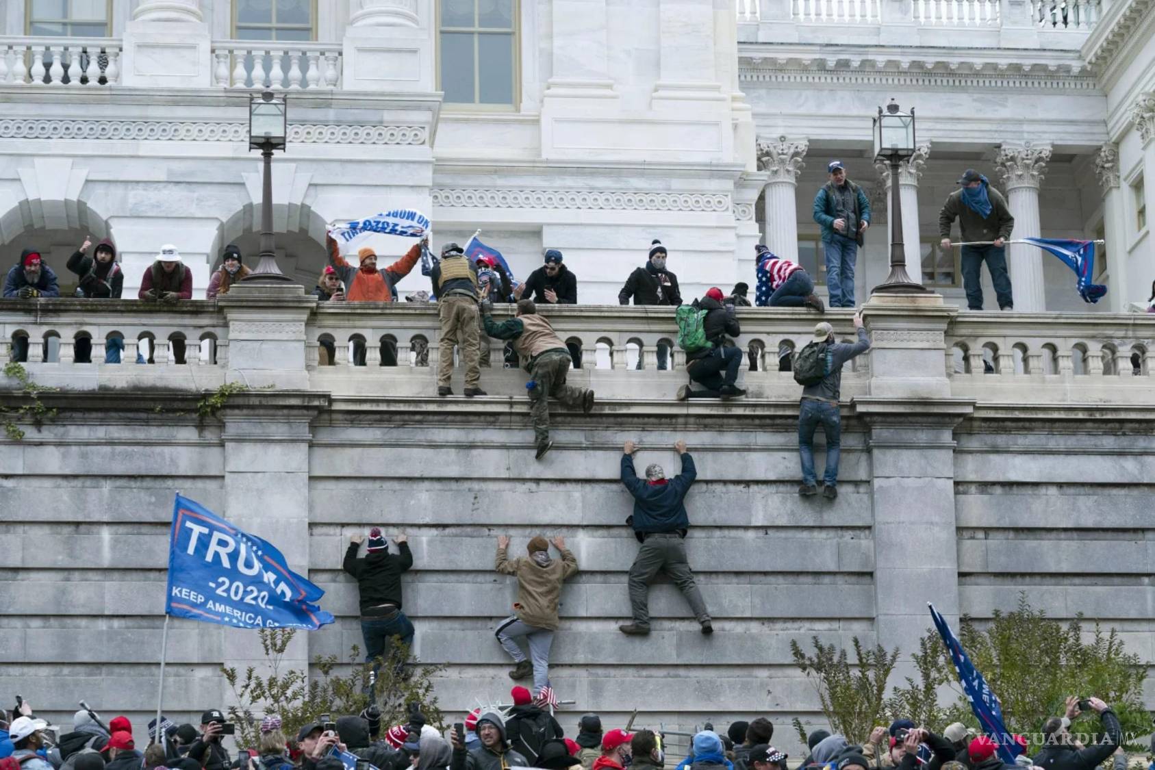 $!Partidarios del presidente Donald Trump trepan por el muro oeste del Capitolio de Estados Unidos el miércoles 6 de enero de 2021 en Washington.